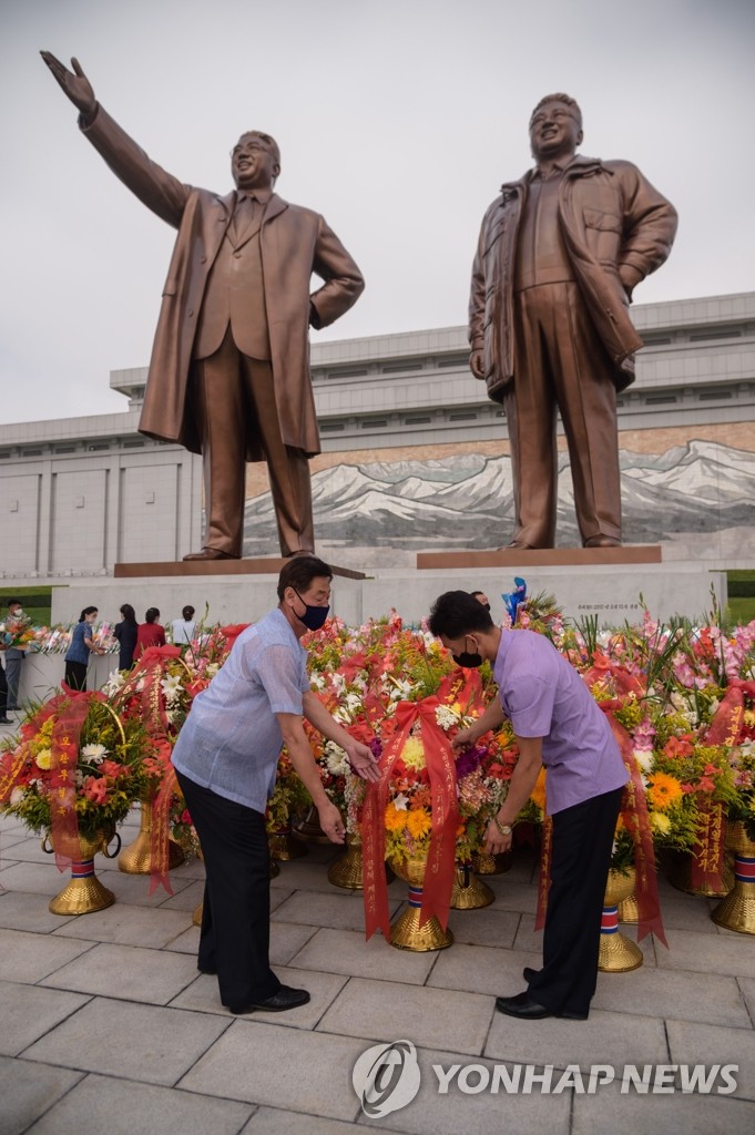 마스크 쓴 채 김일성ㆍ김정일 동상에 헌화하는 북한 주민