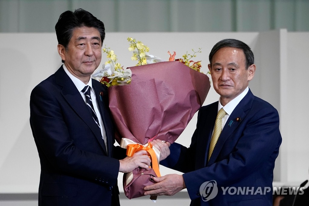 아베 일본 총리로부터 꽃다발 받는 스가 관방장관