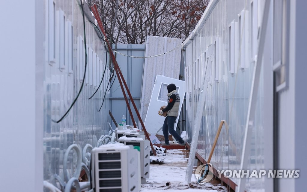 A construction worker builds a container at the Seoul Medical Center on Dec. 13, 2020, as it needs more hospital beds for COVID-19 patients amid a sharp hike in new cases in the Seoul metropolitan area. (Yonhap)