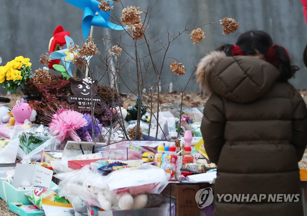 A child pays tribute to a 16-month-old girl, who died in October after alleged abuse by her adoptive parents, in a cemetery in Yangpyeong, east of Seoul, on Jan. 4, 2021. (Yonhap)