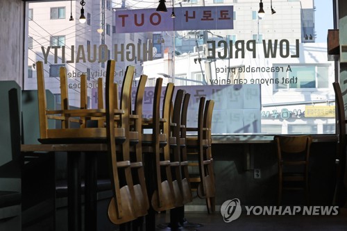 Chairs are turned upside down on tables inside a coffee shop in southern Seoul on Jan. 6, 2021, amid the government's COVID-19 restrictions on dining in at cafes. (Yonhap)