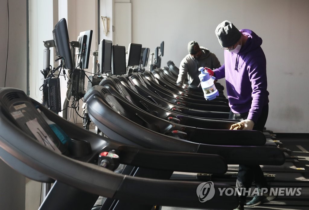 운동기구 소독하는 헬스장 직원들