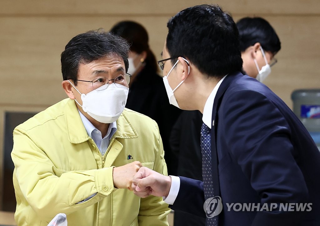 Health Minister Kwon Deok-cheol (L) bumps fists with Choi Dae-zip, head of the Korean Medical Association, before a meeting over COVID-19 vaccination held in Seoul on Feb. 21, 2021. (Yonhap)