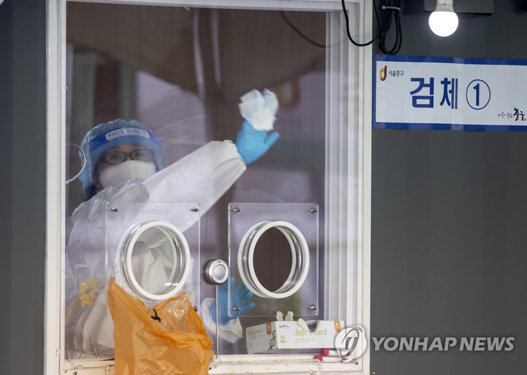 A health care worker prepares for COVID-19 testing at a temporary testing center at Seoul Station in central Seoul on April 8, 2021. (Yonhap)
