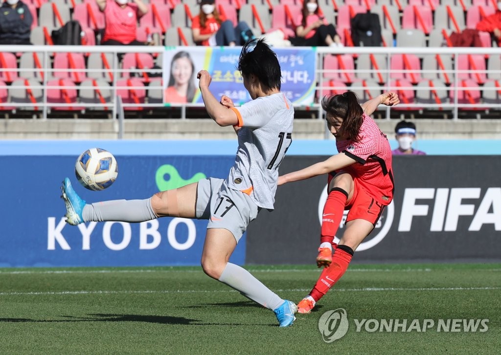 Kang Chae-rim of South Korea (R) takes a shot past Luo Guiping of China during the teams' Olympic women's football qualifying match at Goyang Stadium in Goyang, Gyeonggi Province, on April 8, 2021. (Yonhap)