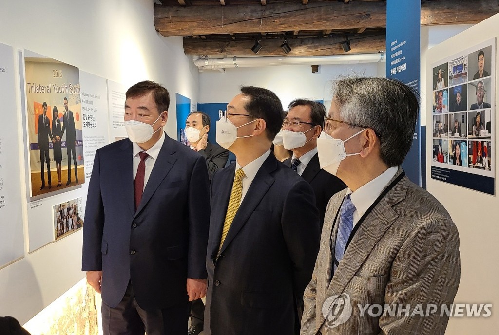 写真展を見学する３カ国の政府代表。前列左からケイ氏、金氏、相星氏＝１４日、ソウル（聯合ニュース）