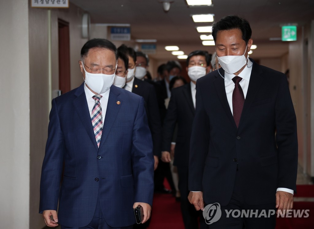Seoul Mayor Oh Se-hoon (R) walks side by side with Finance Minister Hong Nam-ki to a Cabinet meeting at the government complex in Seoul on May 4, 2021. (Yonhap)