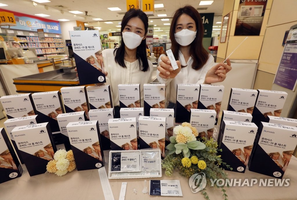 Models present Humasis' COVID-19 self-testing kit at an E-Mart outlet in southeastern Seoul on May 6, 2021, in this photo provided by the discount store chain. (PHOTO NOT FOR SALE) (Yonhap)