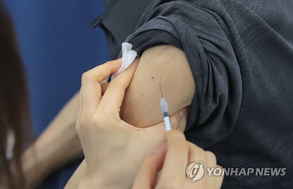 An elderly citizen receives an initial COVID-19 vaccine shot at an inoculation center in Seoul on May 22, 2021. (Yonhap)