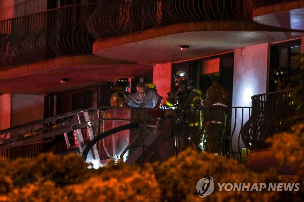 미 마이애미 건물 붕괴 현장에서 주민 구출하는 구조대원들