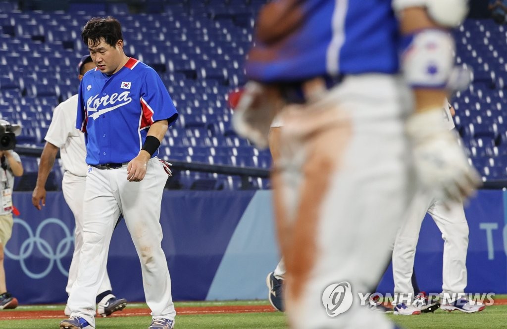 Yang Eui-ji of South Korea (L) walks off the field at Yokohama Stadium in Yokohama, Japan, after losing to the U.S. 4-2 in their Group B game of the Tokyo Olympic baseball tournament on July 31, 2021. (Yonhap)