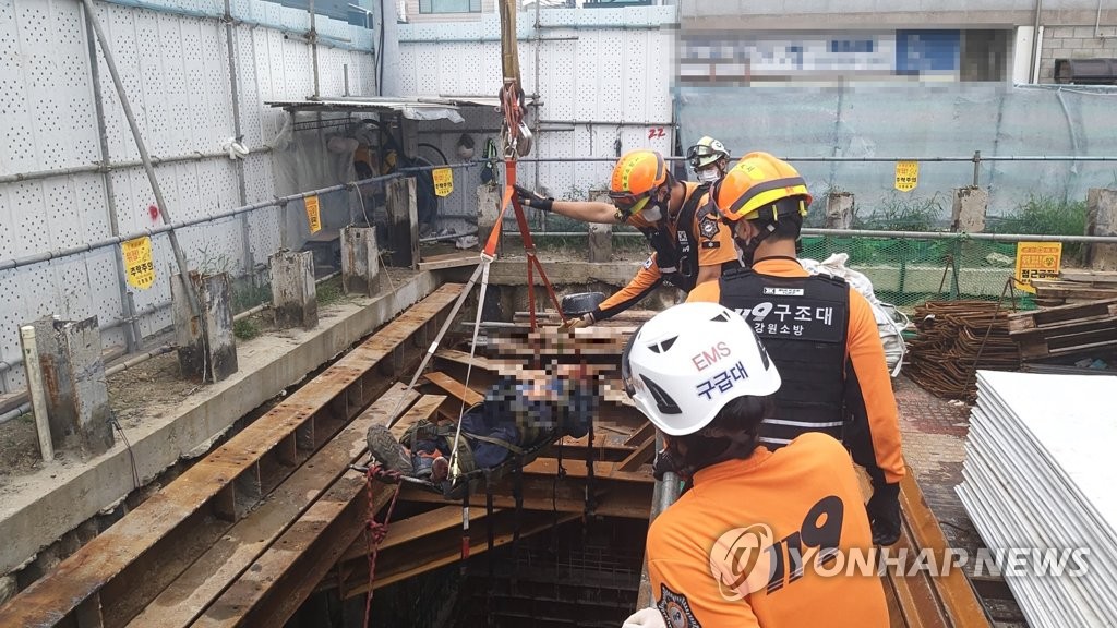 This file photo provided by the Gangwon Fire Headquarters on Aug. 14, 2021, shows emergency responders rescuing a fallen worker at a construction site in Sokcho, Gangwon Province. (PHOTO NOT FOR SALE) (Yonhap)