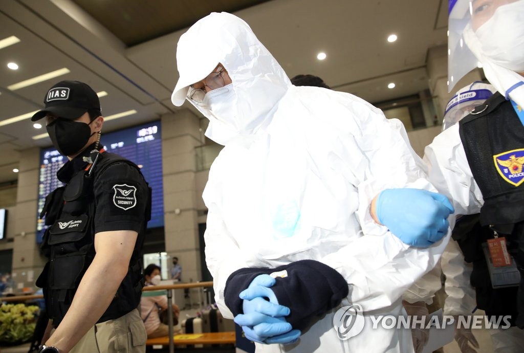 방역복 입고 압송되는 문흥식 전 5·18 구속부상자회장