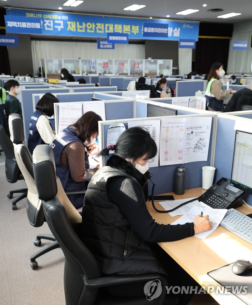 Officials talk with COVID-19 patients receiving at-home treatment over the phone at a disaster center in Seoul on Feb. 21, 2022, when the cumulative number of such patients surpassed 2 million. (Yonhap)