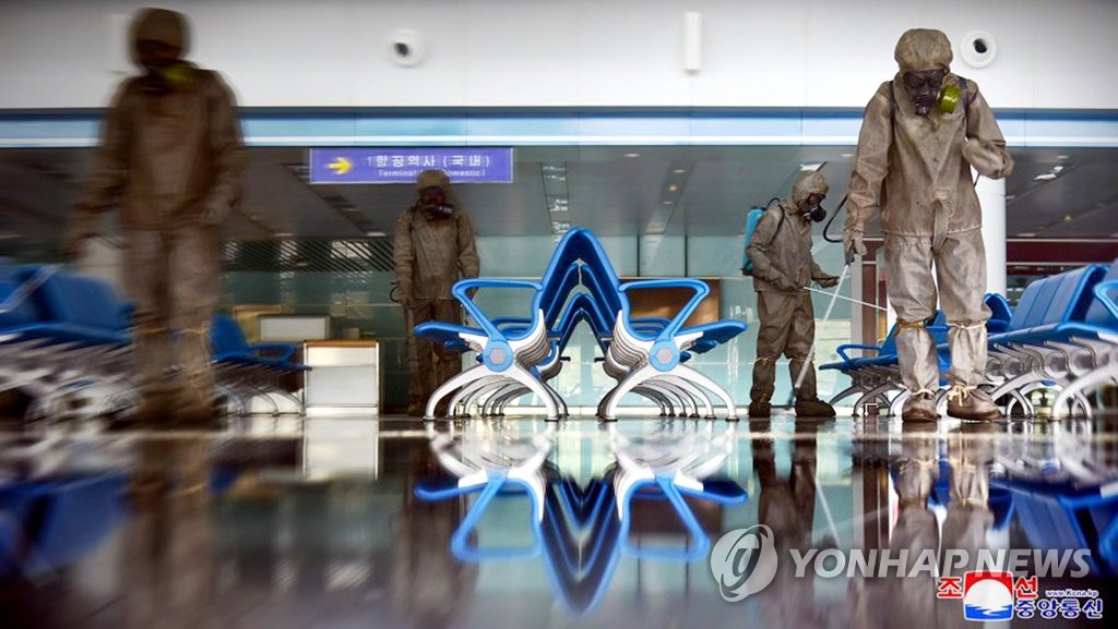 Quarantine officials spray disinfectant at Pyongyang International Airport in the North Korean capital amid the highest-level alert on the coronavirus, in this undated photo released by the North's Korean Central News Agency on June 10, 2022. (For Use Only in the Republic of Korea. No Redistribution) (Yonhap)