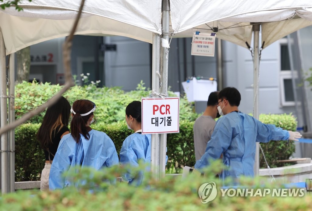 Health workers guide people to a queue at a COVID-19 testing station in the health community center in Seoul's southern district of Seocho, on June 17, 2022. (Yonhap) 