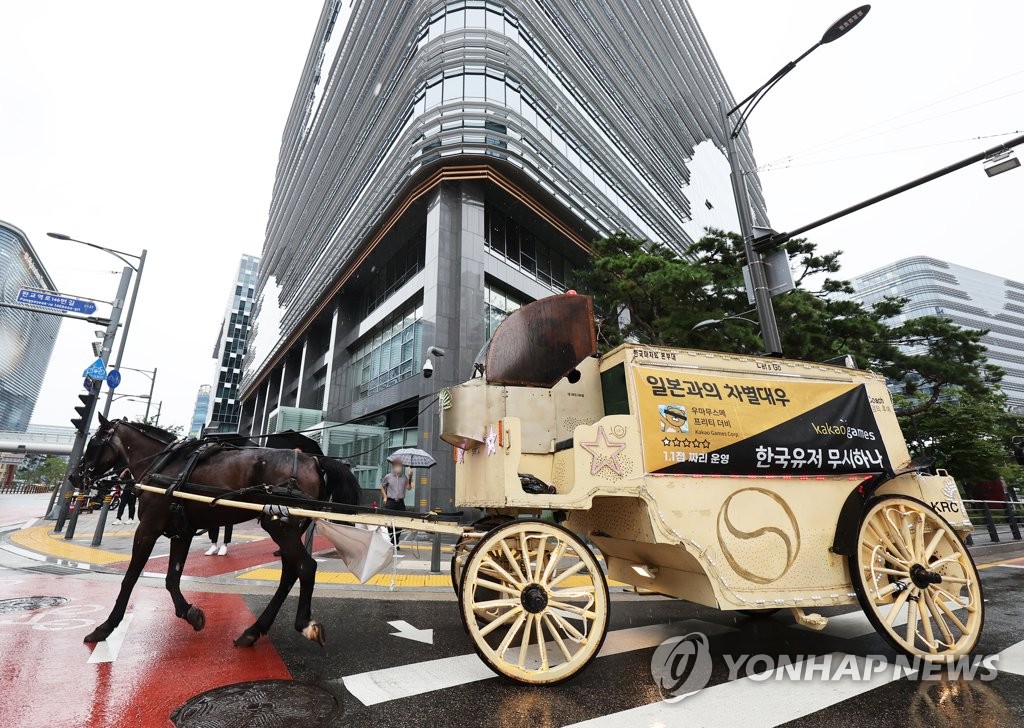 In this file photo, a horse-drawn carriage travels down the street in front of the office building of South Korean gaming company Kakao Corp. in Seongnam, south of Seoul, in protest of the company's purportedly poor management of mobile title "Uma Musume Pretty Derby" on Aug. 29, 2022. (Yonhap)