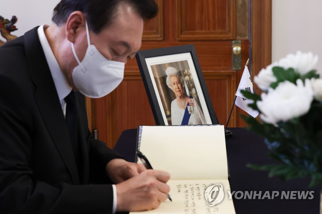 President Yoon Suk-yeol signs a guest book after paying tribute to the late Queen Elizabeth II at a memorial hall set up at the British Embassy in Seoul on Sept. 9, 2022, in this photo provided by his office. (PHOTO NOT FOR SALE) (Yonhap)