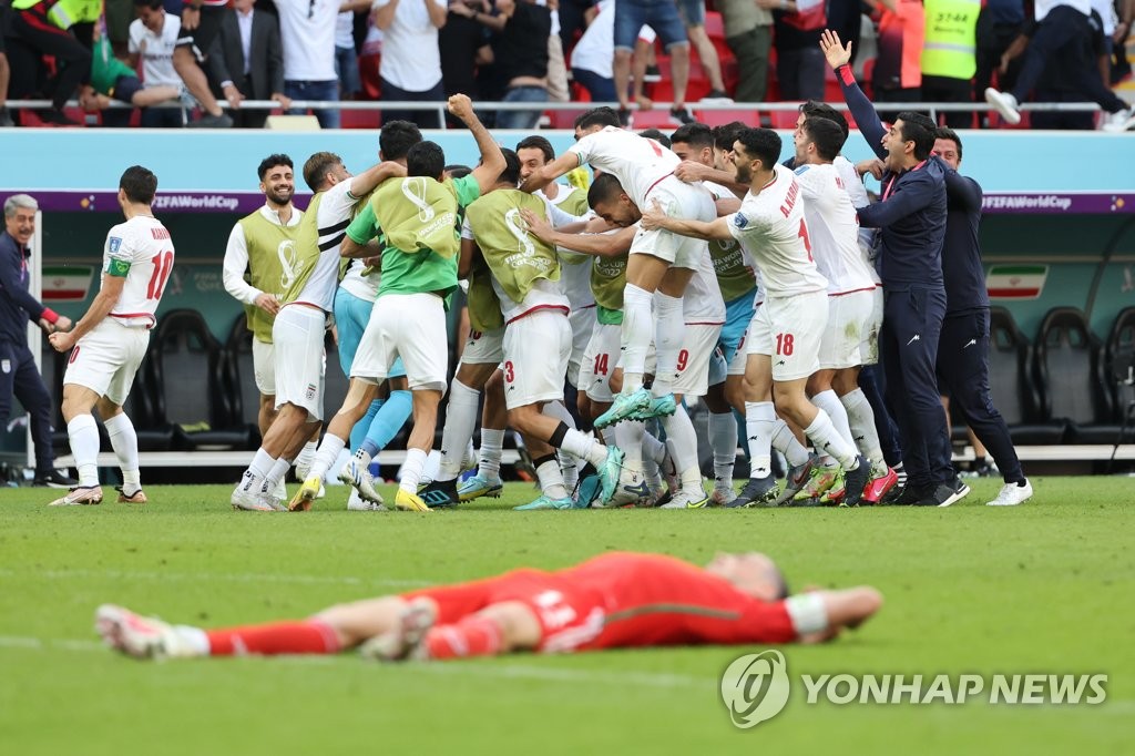 Iran players celebrate a goal by Rouzbeh Cheshmi against Wales during the teams' Group B match at the FIFA World Cup at Ahmad bin Ali Stadium in Al Rayyan, west of Doha, on Nov. 25, 2022. (Yonhap)