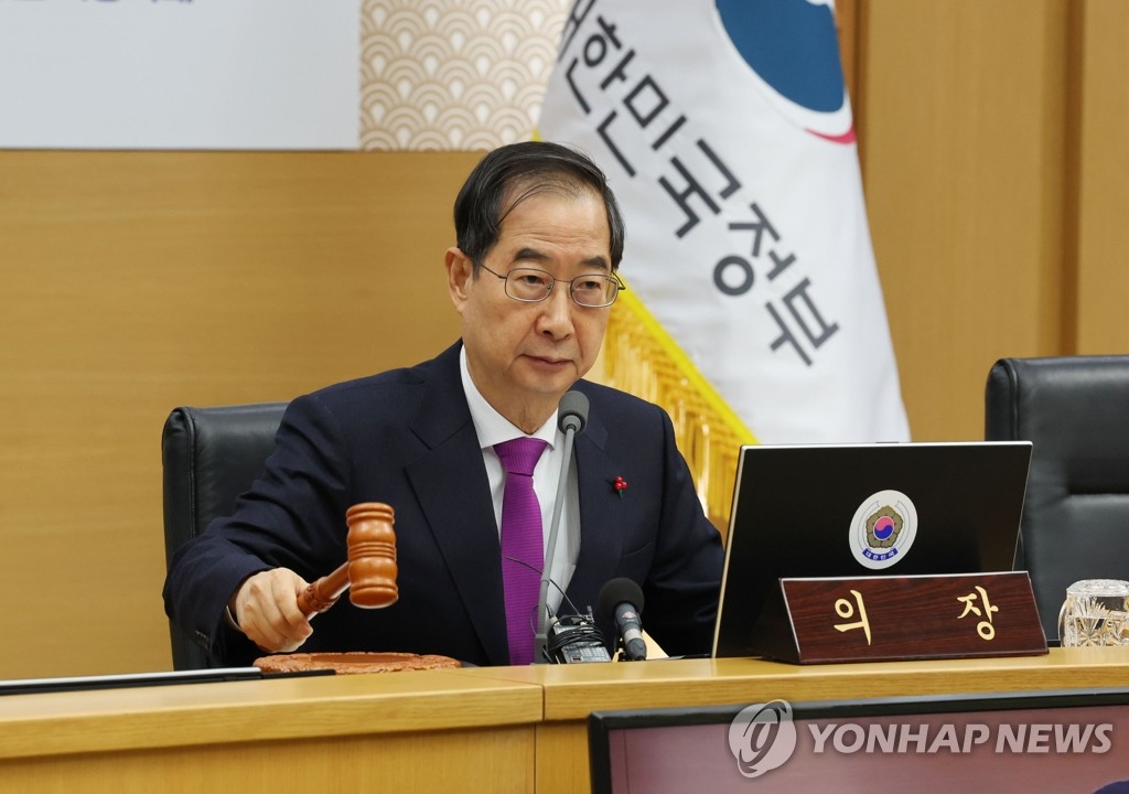 Prime Minister Han Duck-soo bangs the gavel to open a Cabinet meeting at the government complex in Sejong, central South Korea, on Jan. 10, 2023, which is connected via video link with the government complex in Seoul. (Yonhap)