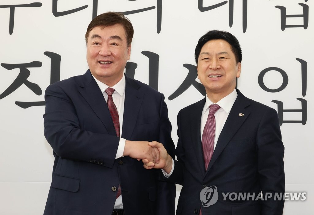 The ruling People Power Party leader Kim Gi-hyeon (R) shakes hands with Chinese Ambassador to South Korea Xing Haiming for a photo during their meeting at the National Assembly in western Seoul on March 28, 2023. (Yonhap)