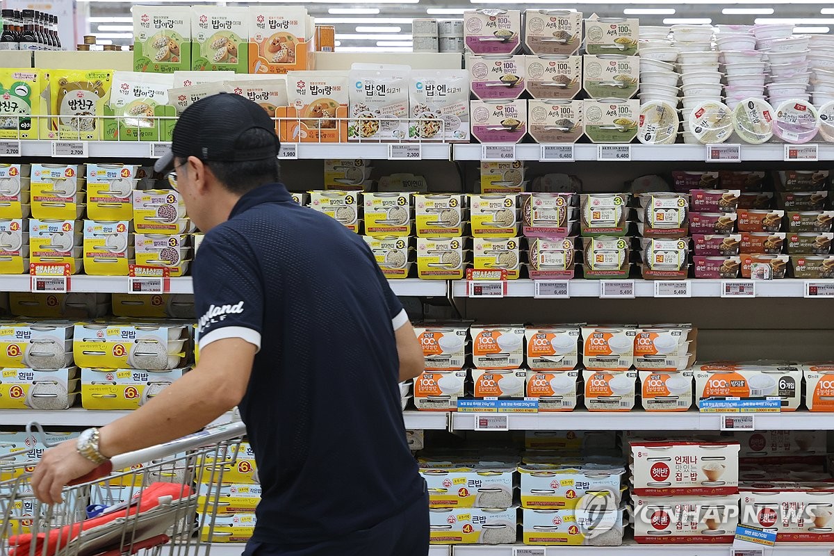 A shopper purchases processed rice products at a supermarket in southern Seoul on Aug. 18, 2024. (Yonhap)