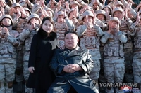 كيم جونغ-أون يلتقط صورة تذكارية مع ابنته الثانية والمساهمين في إطلاق الصاروخ الباليستي العابر للقارات