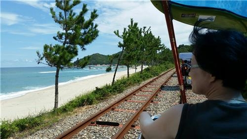 This photo shows a tourist riding the Ocean Rail Bike along Samcheok's beach. (Yonhap)