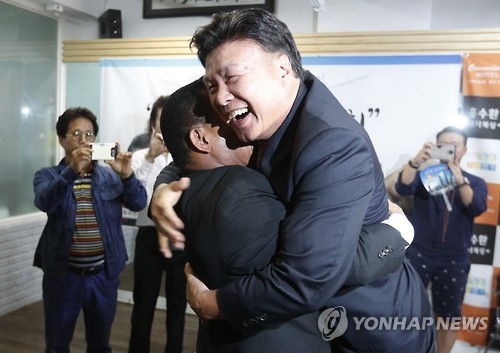 Hong Soo-hwan (R), head of the Korea Boxing Commission, hugs Hector Carrasquilla, a Panamanian boxer-turned-politician, at a boxing gym in Seoul on Sept. 9, 2016. The two former boxers had their first reunion in 17 years. (Yonhap)
