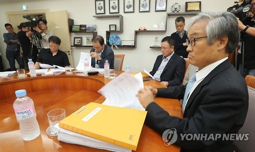 Cho Nam-don (R), head of the K League disciplinary committee, reviews documents before meting out punishment on Jeonbuk Hyundai Motors over bribery scandal at the Korea Football Association headquarters in Seoul on Sept. 30, 2016. (Yonhap)