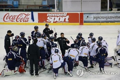 In this undated photo provided by the Korea Ice Hockey Association, South Korean men's national hockey team players huddle around head coach Jim Paek (knelt in center, in black sweats). (Yonhap)