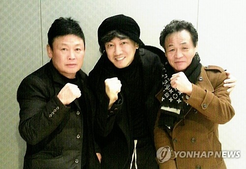 In this photo provided by Buffalo Promotion and Concert World on Feb. 1, 2017, singer Kim Jang-hoon (C) poses with former boxers Yuh Myung-woo (L) and Chang Jung-koo. (Yonhap)