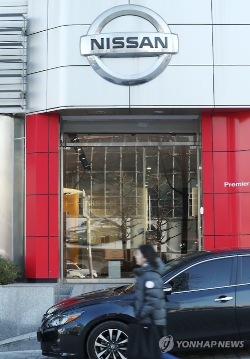 In this file photo taken on Nov. 29, 2016, a woman walks past an outlet of the South Korean unit of Nissan Motor Co. in Seoul. (Yonhap)