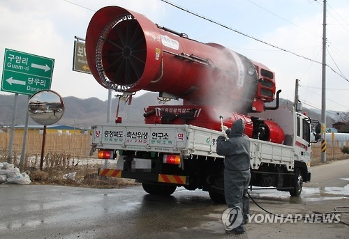 A quarantine official sprays disinfectant on a fumigator truck in Boeun, 180 kilometers southeast of Seoul, on Feb. 9, 2017. (Yonhap) 