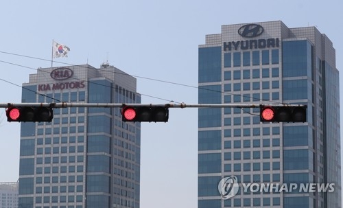 In this photo taken on April 3, 2017, a traffic light turns red against the background of the headquarters of Hyundai Motor Co. and Kia Motors Corp. in Yangjae, southern Seoul. (Yonhap)