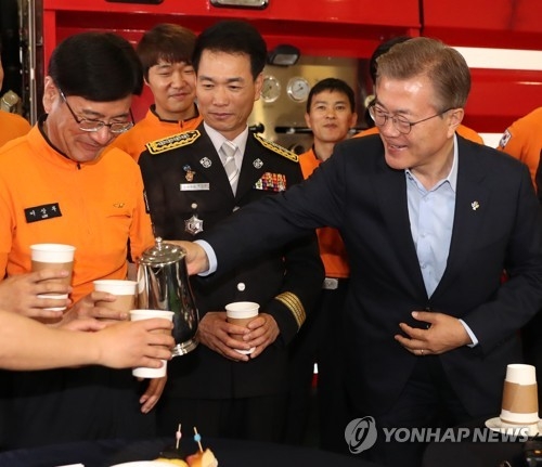 President Moon Jae-in pours coffee for firefighters during his visit to Yongsang Fire Station in central Seoul on June 7, 2017. (Yonhap)