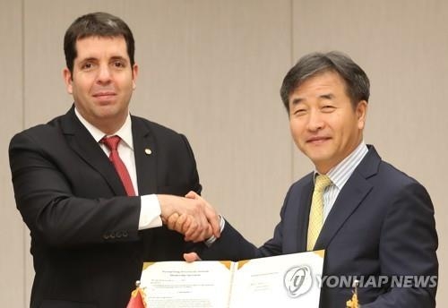 Fabrizio Caligaris, Paraguay's minister of information and communication, shakes hand with Park No-hwang, president and CEO of South Korea's Yonhap News Agency, after signing an agreement on Paraguay's state-run news agency IP's membership of the PyeongChang News Service Network (PNN), Yonhap's content-sharing platform for the 2018 PyeongChang Winter Olympics, on June 14, 2017. (Yonhap) 