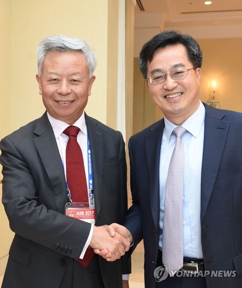 Finance Minister Kim Dong-yeon (R) shakes hands with AIIB president Jin Liqun ahead of talks on June 15, 2017. (Photo courtesy of the Ministry of Strategy and Finance) 