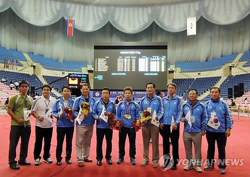 In this file photo provided by the Korea Weightlifting Federation on Sept. 17, 2013, South Korean athletes and officials pose after the Asian Cup and Interclub Weightlifting Championship at Ryugyong Jong Ju Young Gymnasium in Pyongyang. (Yonhap)