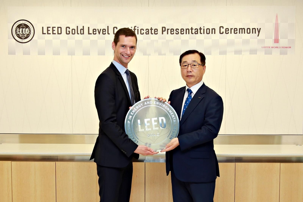 This photo provided by Lotte Corp. shows its CEO Park Hyun-chul (R) posing for a photo with Peter Templeton, senior vice president of the U.S. Green Building Council, at its office in New York on June 20, 2017. (Yonhap) 