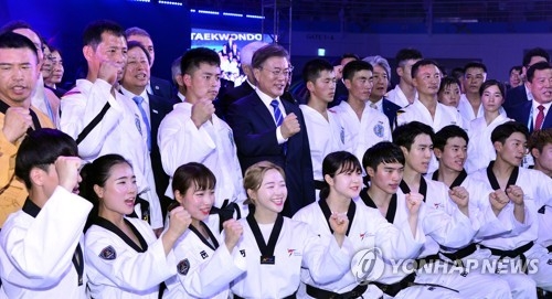 South Korean President Moon Jae-in (fourth from L, back row) pose with taekwondo demonstrators from South Korea and North Korea after the opening ceremony of the World Taekwondo Federation World Taekwondo Championships at T1 Arena in Muju, North Jeolla Province, on June 24, 2017. (Yonhap)