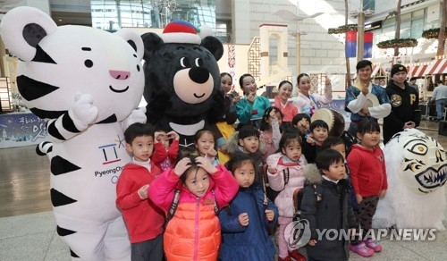 This file photo taken on Dec. 6, 2017, shows South Korean children taking a photo with the PyeongChang Winter Olympic and Paralympic Games mascots at Incheon International Airport. (Yonhap)