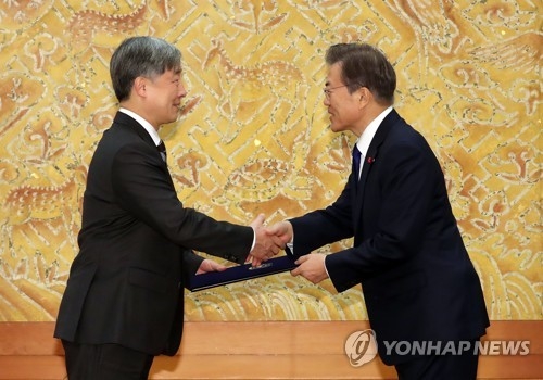 President Moon Jae-in (R) shakes hands with the new head of the Board of Audit and Inspection, Choe Jae-hyeong, after presenting him with a certificate of appointment in a ceremony held at his office Cheong Wa Dae on Jan. 2, 2018. (Yonhap)