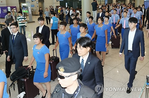 Members of the North Korean delegation for the Asian Games (in blue outfits) arrive at Incheon International Airport, west of Seoul, on July 29, 2018, to begin joint training with South Korean athletes. The Koreas will field unified teams in women's basketball, dragon boat racing in canoeing and three events in rowing at the Aug. 18-Sept. 2 Asian Games in Indonesia. (Yonhap)