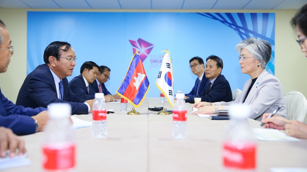 South Korean Foreign Minister Kang Kyung-wha talks with her Cambodian counterpart, Prak Sokhonn, in Singapore on Aug. 1, 2018 in this photo provided by her ministry. (Yonhap)