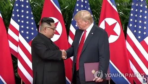 This photo, captured from The Straits Times, shows U.S. President Donald Trump and North Korean leader Kim Jong-un shaking hands after signing an agreement at the Capella Hotel in Singapore on June 12, 2018. (Yonhap)