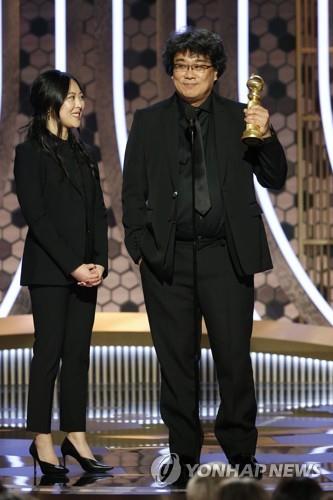 In this image released by NBC and moved by the Associated Press, South Korean director Bong Joon-ho (R) accepts the award for best foreign language film for "Parasite," with interpreter Sharon Choi standing next to him, at the 77th Annual Golden Globe Awards at the Beverly Hilton Hotel in Beverly Hills on Jan. 5, 2020. (Yonhap)