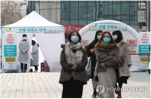 People wearing masks walk past a novel coronavirus screening clinic in Myeongdong in downtown Seoul on Feb. 2, 2020. (Yonhap)