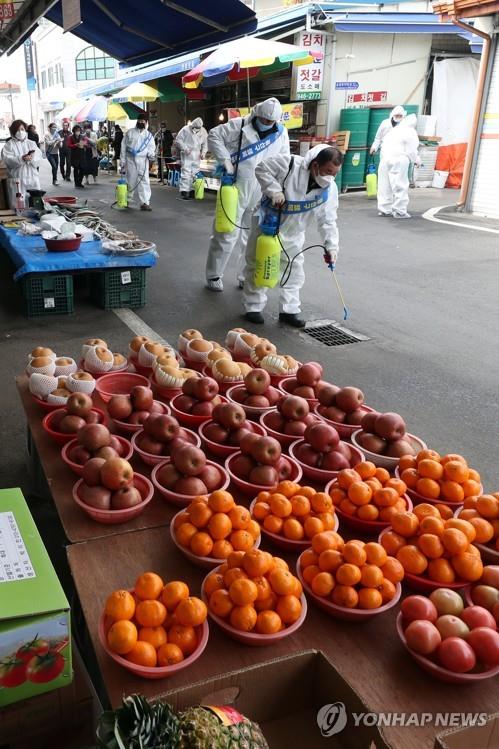 Workers disinfect a market in the southern city of Gwangju, South Korea, on Feb. 11, 2020, amid fears over the spreading new coronavirus. (Yonhap)