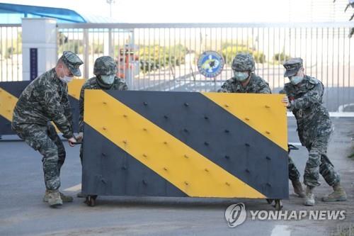 Soldiers set up a roadblock in front of a Navy base to limit visitors on Feb. 21, 2020, in the wake of a confirmed case of the new coronavirus among its service personnel. (Yonhap)